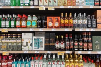 Athens, Greece - March 6, 2023: Tequila gin and rum alcohol beverage bottles various labels for sale at liquor store.