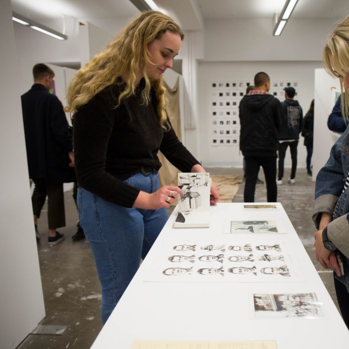 Two blonde girls browse the Honours Art and Design Gallery