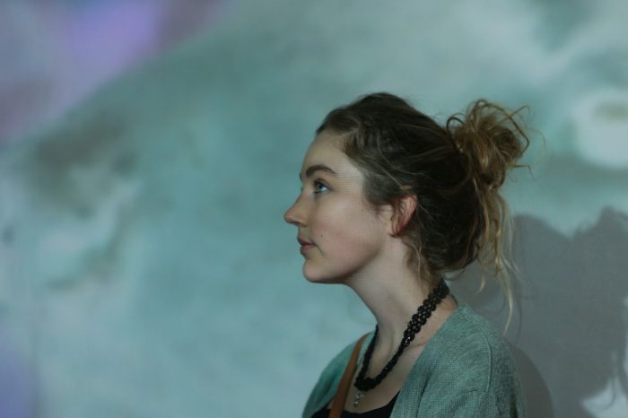 Female student standing in front of colourful background