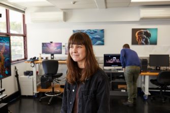 Student using virtual reality headset and controls in 3D Visualisation Aesthetics Lab.