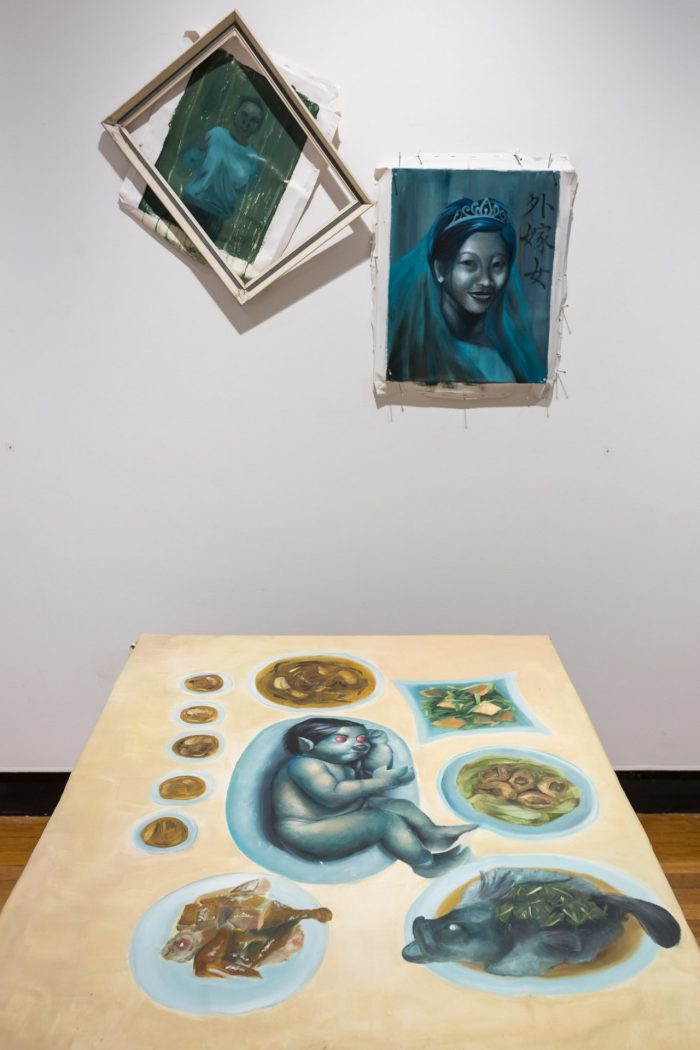 Lok Yin Law, ‘Dinner, in the making’ 2025. Oil on canvas; On table: ‘Just a family reunion’, 134 x 105cm; Wall works: ‘外嫁女 (Married Daughter)’, 40 x 50cm, ‘Wet paint’, 40 x 50cm. 