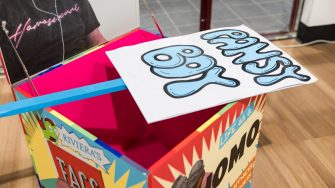 Mark Wilson, ‘I have (something) a lot to say’ 2025. Acrylic screen print and aerosol on wood, paint marker, paper and corflute; Box: 60 x 60 x 60cm each; Pickets: approx. 120 x 55cm each.