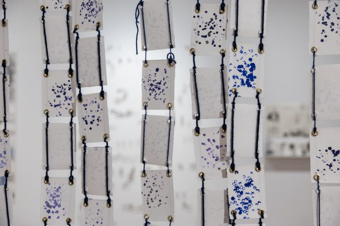 Fatima Naqvi, ‘Blind Faith’ (2025). Blue ink stamped with prayer bead on 99 A7 panels joined together using eyelet rings and blue thread; 94.5cm x 81.4cm. Photograph: Anna Kucera.