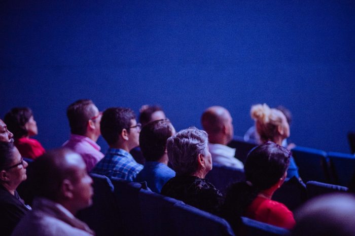 Audience sat in a cinema watching a movie that's out of shot