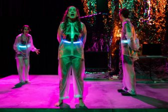 three students acting on stage