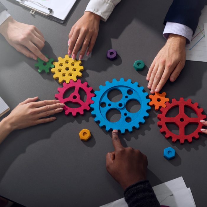 Teamwork of businesspeople work together and combine pieces of gears. Partnership and integration concept