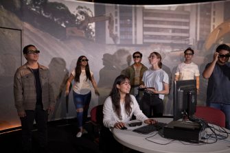 Students and teacher operate learning in a virtual reality cinema.