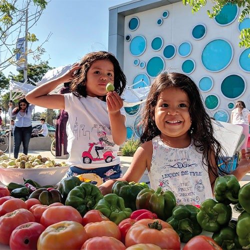 two girls smiling with fresh produce