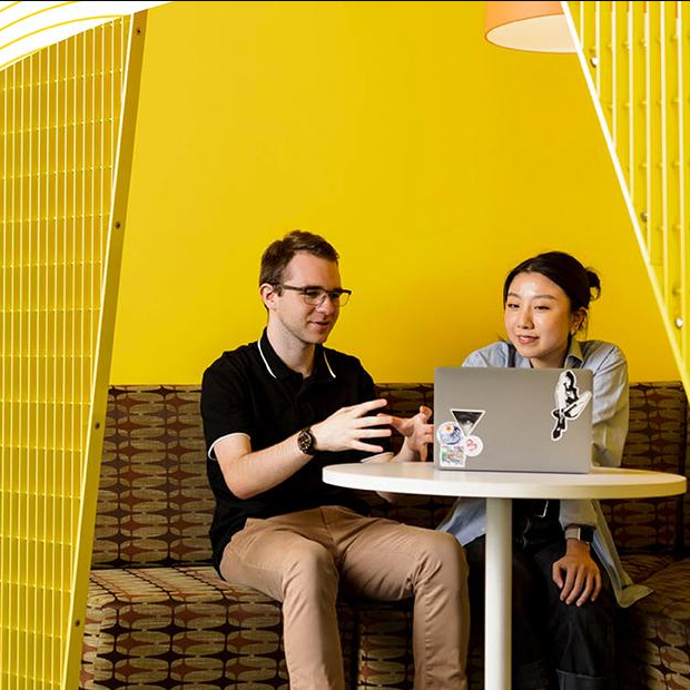 Two alumni in cafe with laptop