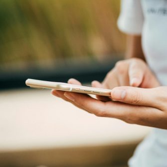 Close up of a woman's hands holding a mobile phone with a blurred background