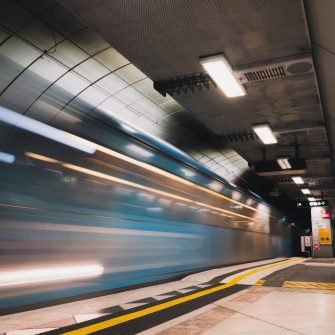 A blurred train speeds through a subway station
