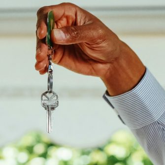Close up of a hand holding a silver key