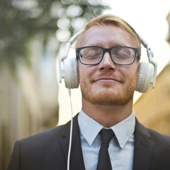 A person smiles wearing headphones