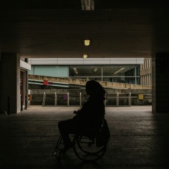 Silhouette of a person in a wheelchair in a dark garage