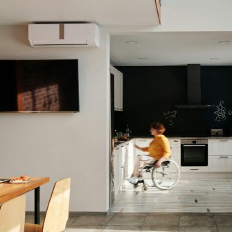 A person in a wheelchair uses the stove in a kitchen