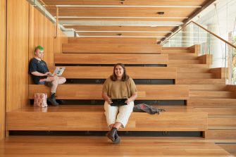 Art and design students discussing work inside the Red Center build enviroment study space.
