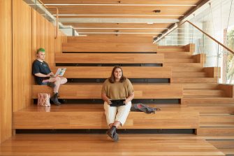 Art and design students discussing work inside the Red Center build enviroment study space.