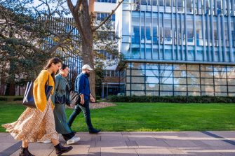 Three students walking on main walkway