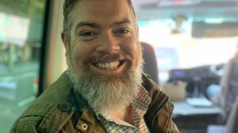 Headshot of Tom Dawkins on Road Trip bus