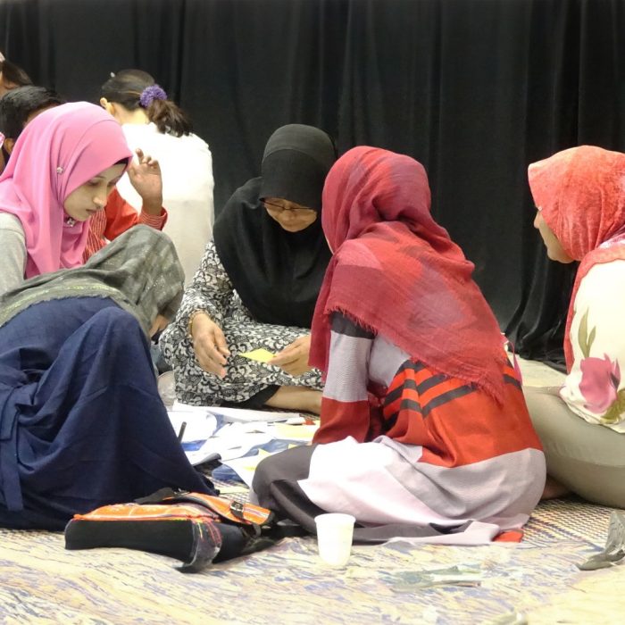 Refugee girls sitting in a circle drawing