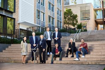 UNSW Alumni sit and stand on campus steps at Kensington campus