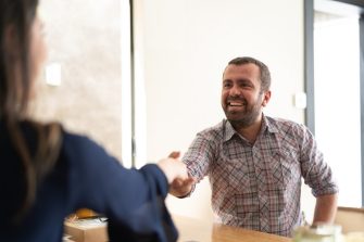 Man signing contracts and handshake with a business woman stock photo