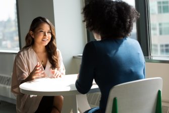 Two women chatting around a table
