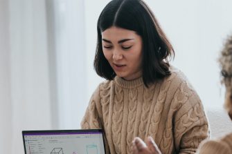Woman sitting on a couch and presenting a graph on her laptop