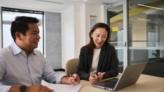 AGSM students working together from a laptop in a classroom on campus