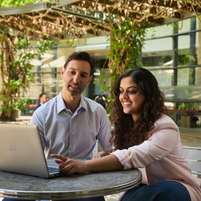 AGSM at UNSW students working together with a laptop outside in the courtyard on campus