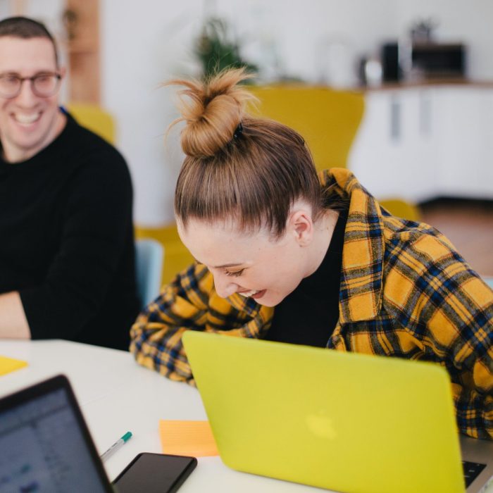 Two people in an office chatting and smiling