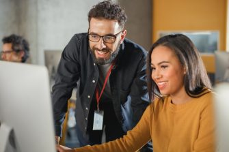 Lecturer Helps Scholar with Project, Advising on Their Work. Teacher Giving Lesson to Diverse Multiethnic Group of Female and Male Students in College Room, Teaching New Academic Skills on a Computer.