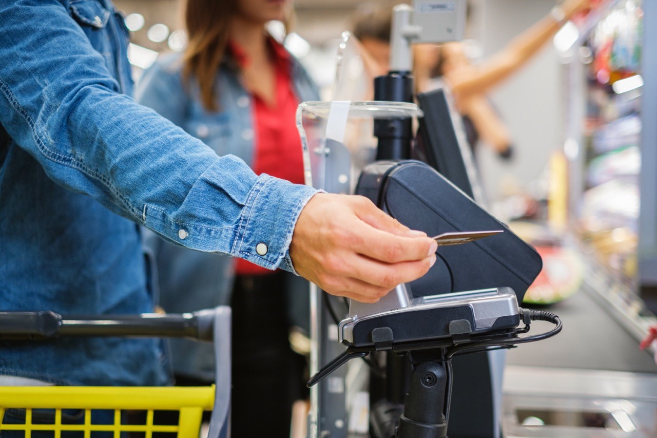 Man paying with NFC in a grocery store.