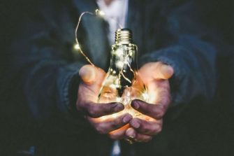 Man holding a lit light globe