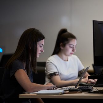 Students studying on computers in the business school computer lab.