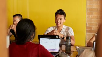 Students relaxing with computers, talking and studying at Kensington UNSW