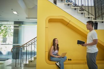 Students talking and laughing at "The Place" inside the business school at UNSW.