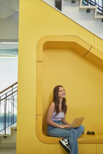 Students talking and laughing at "The Place" inside the business school at UNSW.