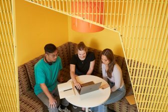 Students talking and laughing at "The Place" inside the business school at UNSW.