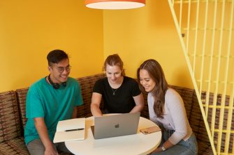 Students talking and laughing at "The Place" inside the business school at UNSW.
