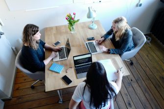 Three women sitting and facing eachother