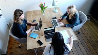 Three women sitting and facing eachother