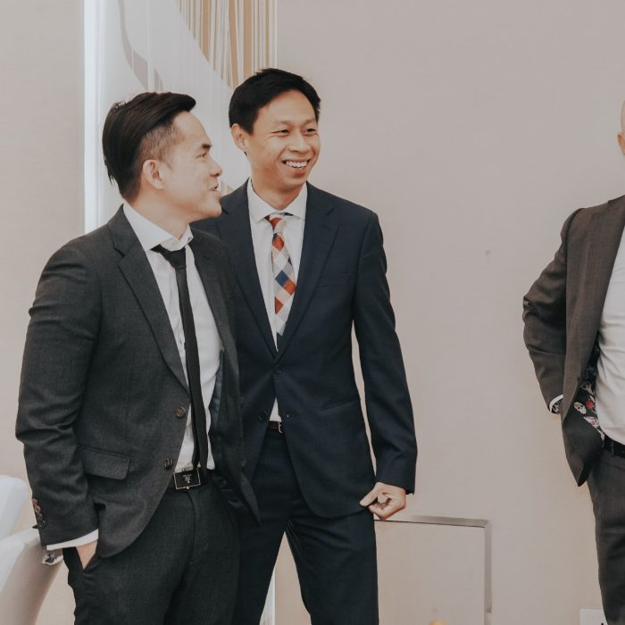 Group shot of 4 men chatting and smiling at a UNOVA event