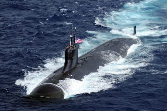 A US seawolf submarine travels on the ocean surface at speed