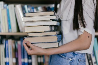 Woman holding stack of books