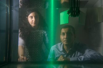 Dr Soudeh Mazharmanesh and Dr Sridhar Ravi from the University of NSW Canberra watch illuminated particles flow through a tank while testing a wing shape. The researchers work examines how insects can give insights into drone engineering.