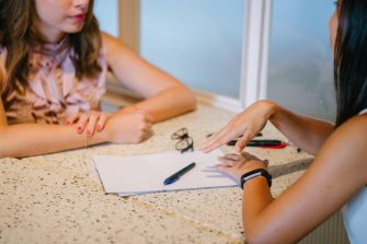 Two women talking at a desk