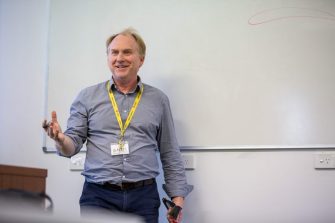 Research supervisor standing at whiteboard