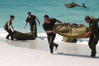 Military personnel landing on a beach