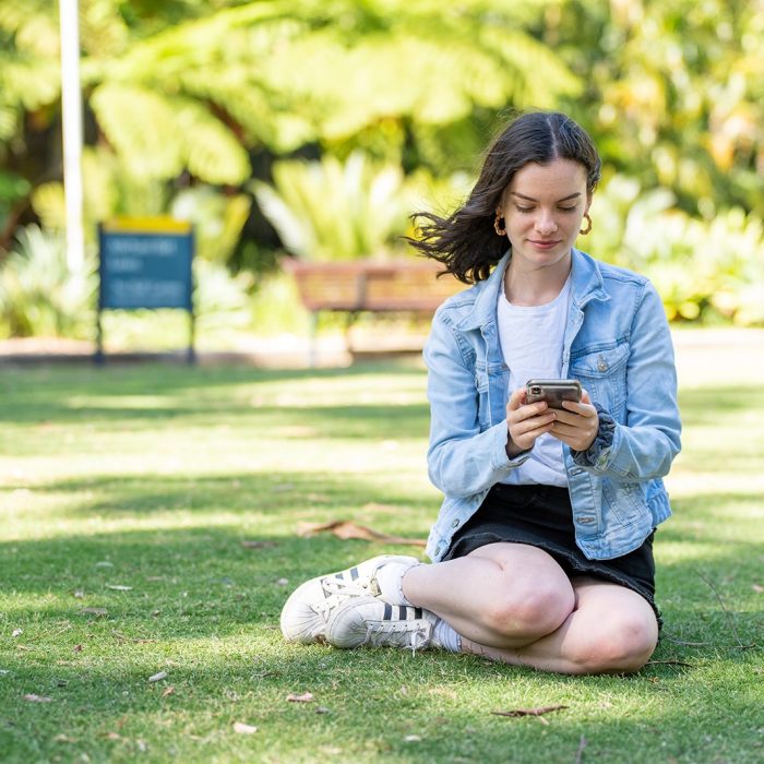 A student sitting on the Michael Birt Lawn